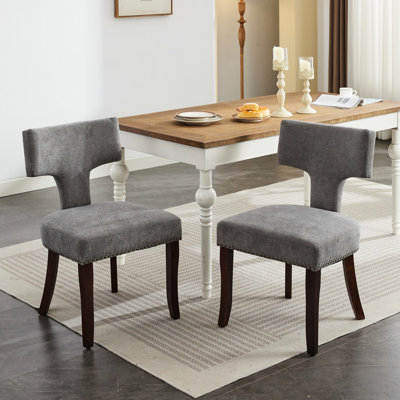 Deux chaises de salle à manger de style Mid-Century moderne revêtues de lin gris avec des clous courbés et cuivrés, un cadre confortable en bois franc et deux chaises confortables en mousse, gris. Clous en tissu. Structure, coussin. Élégant et