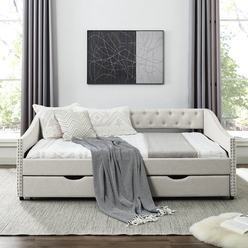 Lit de jour rembourré beige avec tiroirs, boutons de dossier et accoudoirs garnis de clous en cuivre pour un revêtement en tissu pleine grandeur élégant, style bouton de confort