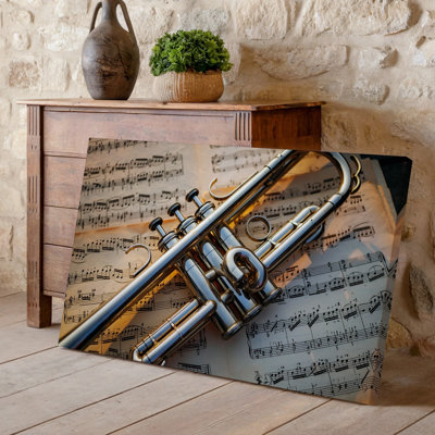 Toile, art photographique en gros plan d'une trompette argentée polie positionnée en diagonale sur une feuille de musique rétro