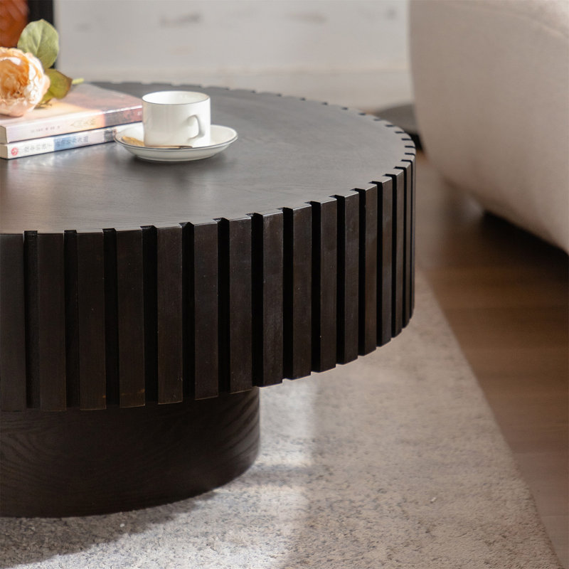 Table basse ronde avec relief fabriqué à la main et piédestal robuste, conception en forme d'olive pour un décor de salon élégant