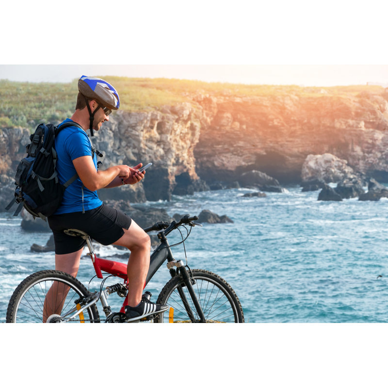 Mountainbiker utilisant un téléphone intelligent sur un rocher par Valentinrussanov, H 8 po x l 12 po