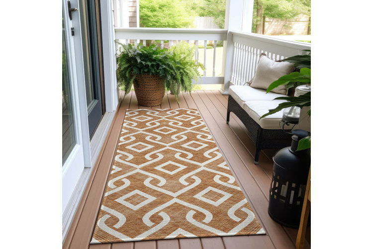 Narrow front porch with a patterned runner rug, a large potted fern, and a small armless loveseat.