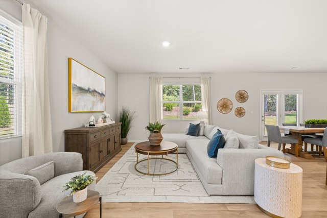 Living room with sectional sofa, accent chair, and wood cabinet.