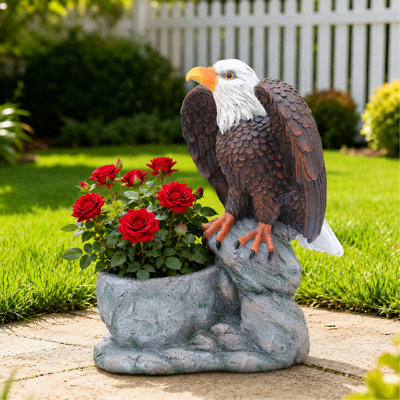 Statue de jardin debout sur une base en fausse pierre avec pot de fleurs rustique