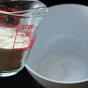 A jug of flour next to a bowl of water for the salt dough recipe