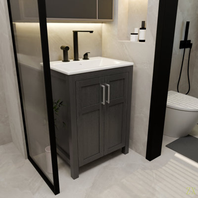 Une armoire de salle de bain de 24 pouces, jumelée à un lavabo en céramique, possède un design moderne et est faite de matériaux imperméables et durables.