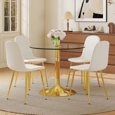 Ensemble de table et de chaises. Une table de salle à manger ronde en verre trempé transparent de 35 po avec support et base en métal. Elle est assortie de 4 chaises de salle à manger à haute résilience avec pieds en métal