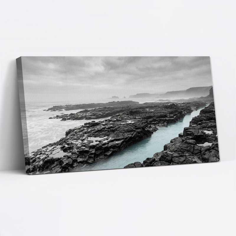Tableau sur toile représentant une côte rocheuse en noir et blanc avec des eaux turquoise, 46“W x 24”H