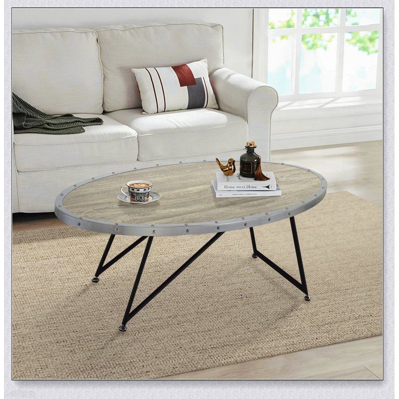 Table basse ovale en chêne gris patiné et noir, alliant charme industriel et élégance moderne pour des espaces de vie élégants.