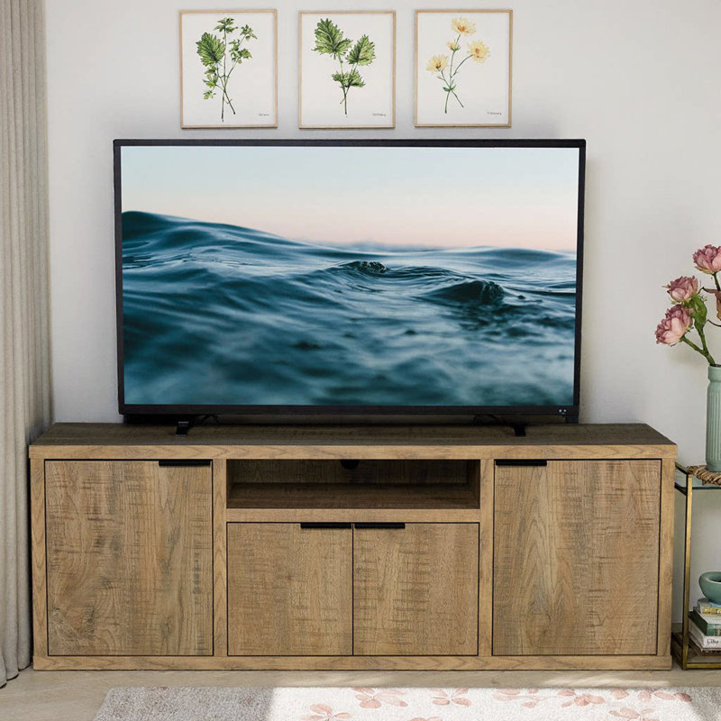 Elevate your living space with the Noriega Mango 4-Door TV Stand, a charming blend of rustic elegance and modern functionality.