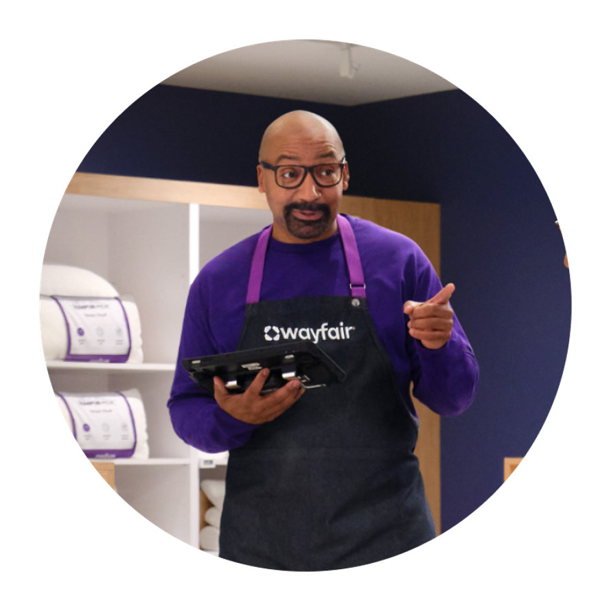 Wayfair associate wearing apron and holding a tablet