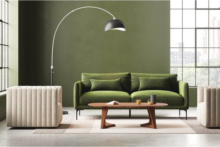 green living room with a dark olive green sofa and arched metal floor lamp