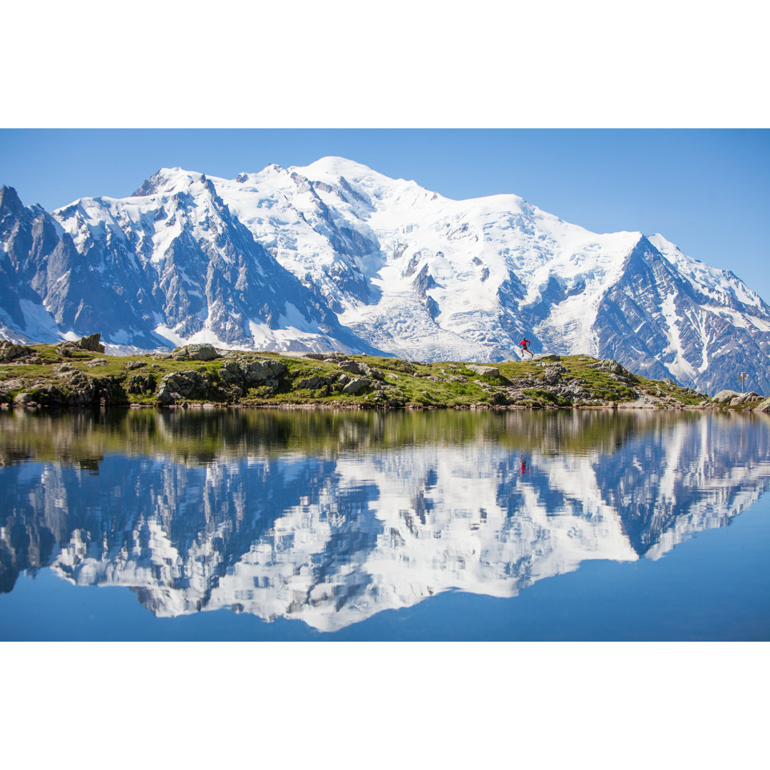 Spiegelung auf kristallklarem Bergsee, laufender Mann