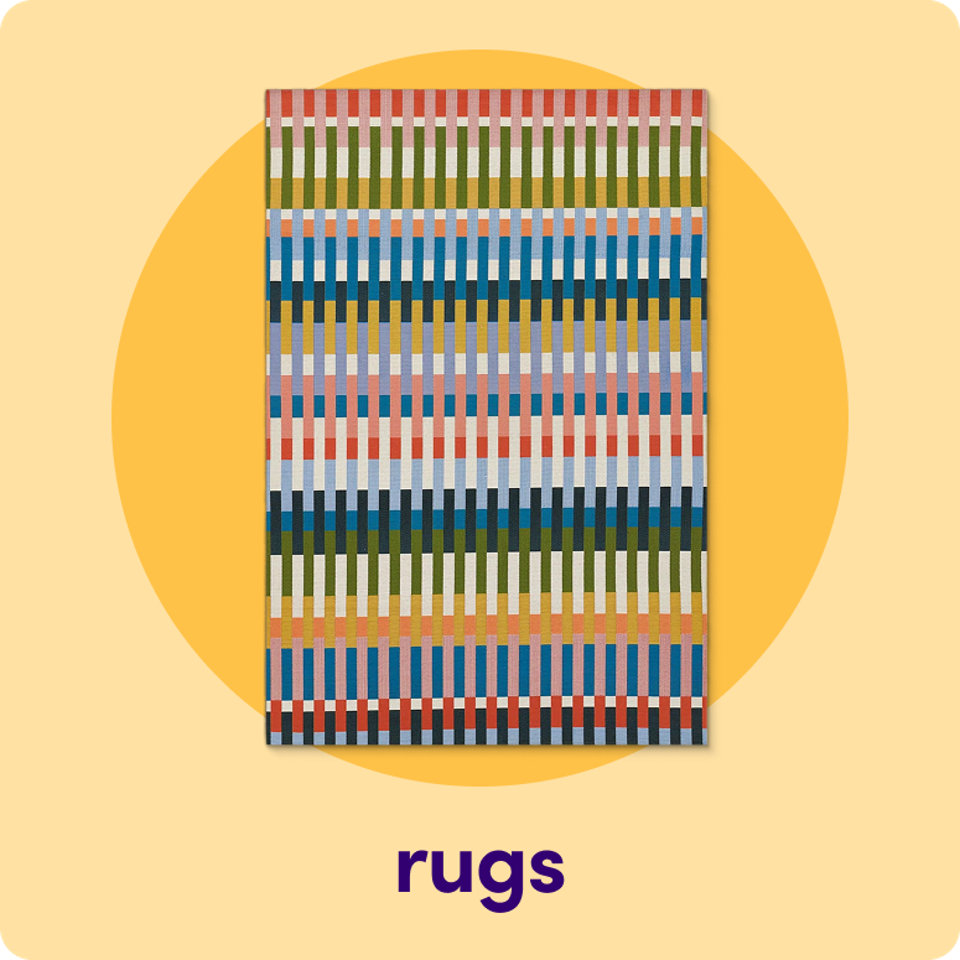An outdoor rug featuring a vibrant, multi-colored vertical stripe pattern on a yellow circular background.