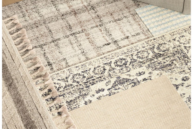 Beige and cream area rugs layered on top of each other.