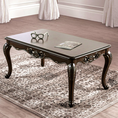 Table basse de style traditionnel avec pieds incurvés, design sculpté, structure en bois massif, finition Java