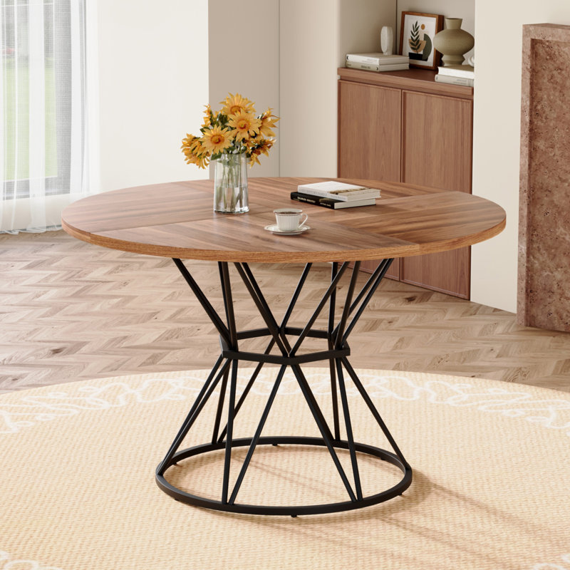 Une table de salle à manger circulaire d'un diamètre de 47,3 pouces, comprenant 4 plateaux de table en bois aggloméré à grain de bois de noyer, des supports en métal en forme de sablier et une table de salle à manger de style industriel moderne pour 4 à 6 personnes.
