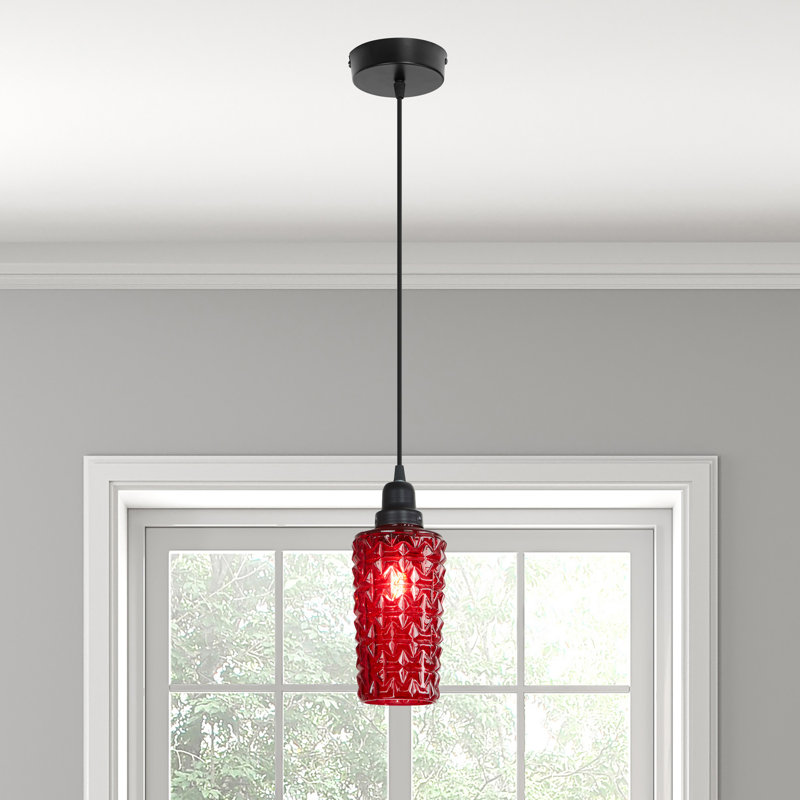Single red glass pendant light with black fixture hanging in front of a window in a modern gray-walled room
