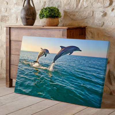 Toile d'un paysage marin serein mettant en vedette deux dauphins sautant gracieusement hors de l'art mural The Sparkling Turquoise Ocean créant des éclaboussures d'art sur toile