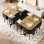 Un ensemble de table à manger et de chaises carrées de 9 pièces avec un plateau de table en grain de bois bicolore et 8 chaises en cuir noir, idéal pour les réunions de famille de jusqu'à 8 personnes.