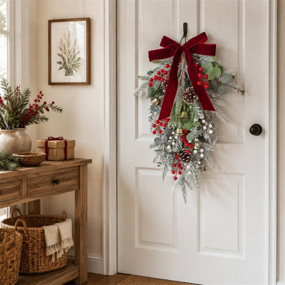 Guirlande de Noël artificielle floquée de 60 cm (23,6 pouces) en forme de larme, décoration murale ou de porte hivernale avec nœud en velours rouge, baies, pommes de pin et clochettes dorées