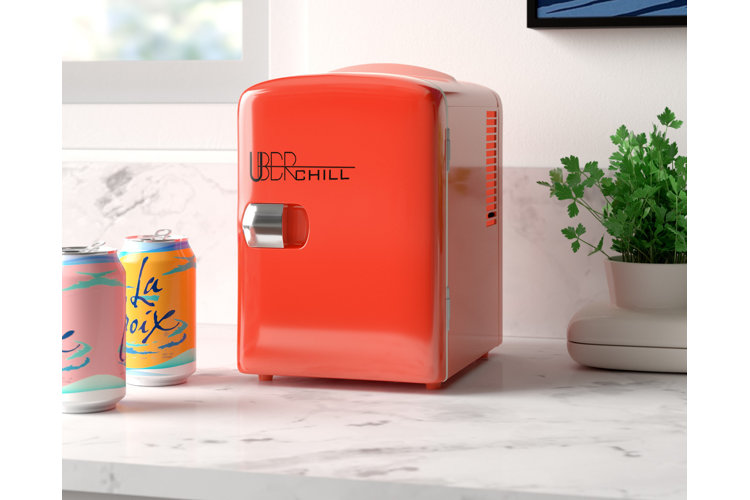 miniature fridge on desk filled with soda cans