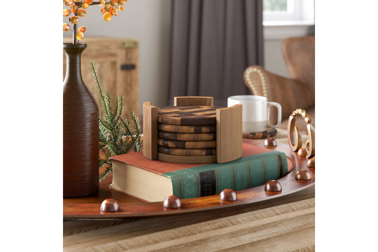 wood coaster set in a holder placed on a book and next to a vase