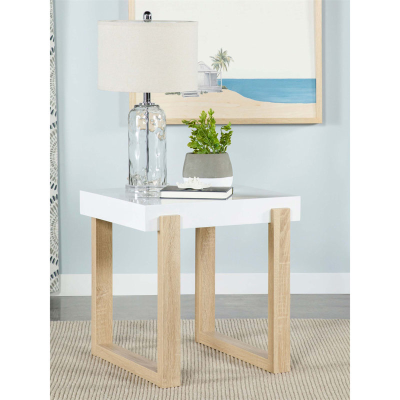 La table de bout Gwen, blanche, lustrée et naturelle avec base luge, allie élégance moderne et design fonctionnel pour tout espace de vie.