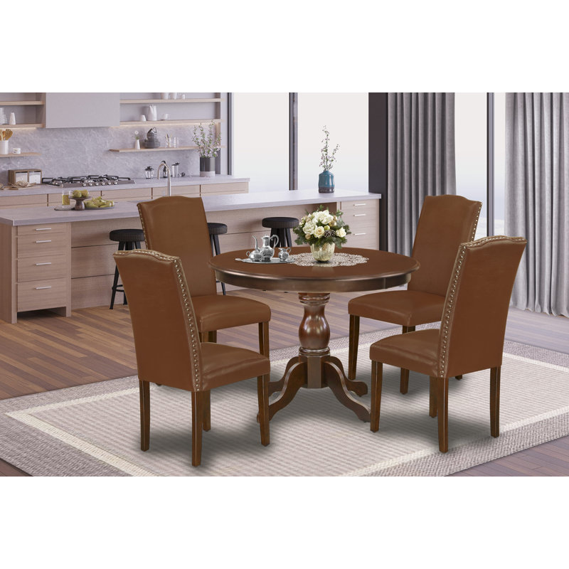 Cet ensemble de salle à manger 5 pièces comprend une table de salle à manger ronde avec piédestal et 4 chaises Parson revêtues de similicuir brun, acajou