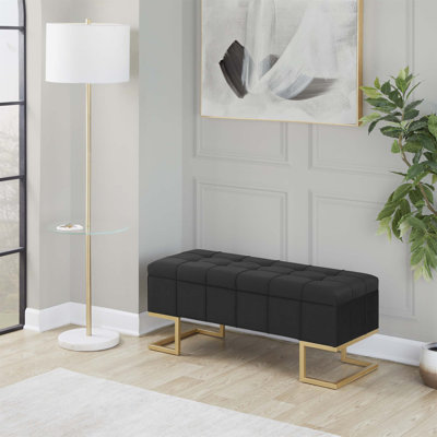 Élégant banc de rangement en velours capitonné avec pieds en métal doré, pour une décoration moderne et des sièges supplémentaires.