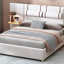 Grand lit avec coussins intégrés, revêtement en velours beige et orifices de sortie, lit à tablettes latérales, rangement de chevet à deux prises, conception tendance