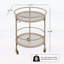 Chariot-bar rond avec tablettes en verre trempé et accents dorés, finition blanche vieillie, idéal pour les décors modernes et rétro