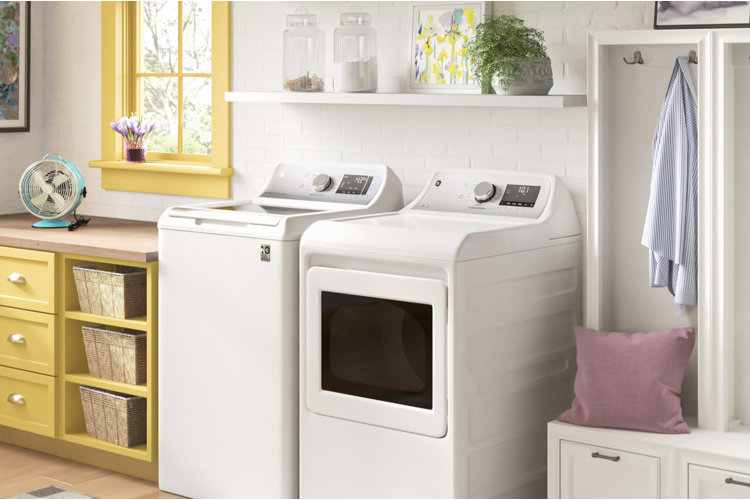 laundry room with white side-by-side washer and dryer and yellow cabinets