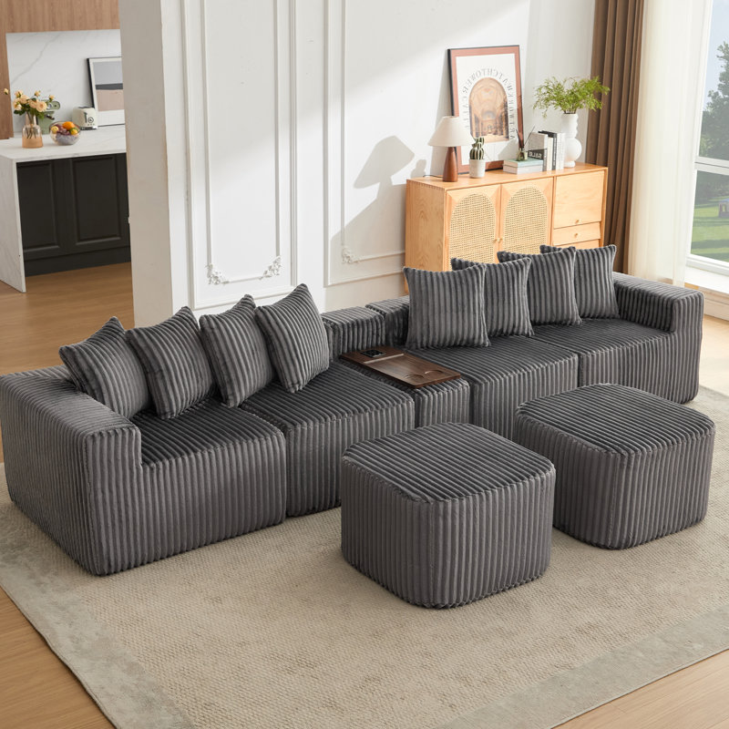 Canapé modulaire en U avec chargement sans fil, ports USB, table basse mobile et sièges reconfigurables pour des espaces de vie flexibles.