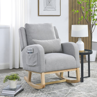 Fauteuil à bascule de salon moderne à dossier haut avec un coussin lombaire, deux poches latérales et un ours en peluche.
