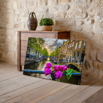 Canvas A Picturesque Amsterdam Canal Scene During Springtime Featuring Vibrant Pink Wall Art Tulips In Full Bloom Prominently Canvas Wall Art
