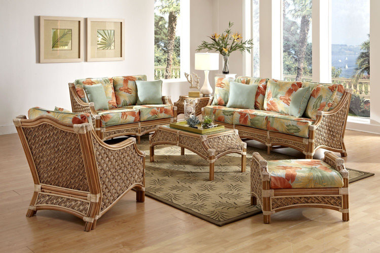 tropical-inspired living room with wicker furniture, floral cushions, glass-top coffee table, and leafy decor