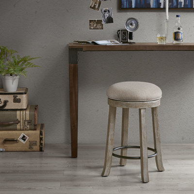 Tabouret de comptoir rotatif à 360 degrés avec siège gris texturé et pivot rembourré patiné et structure en bois légèrement rustique