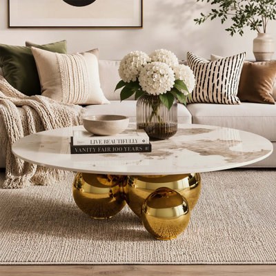 Table basse ronde dorée avec piédestal en acier inoxydable et plateau en faux marbre, durable et élégante pour les espaces de vie modernes