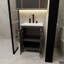 L'armoire de salle de bain noire de 24 pouces, jumelée à un lavabo en céramique blanche, présente un design moderne et est faite de matériaux imperméables et durables.