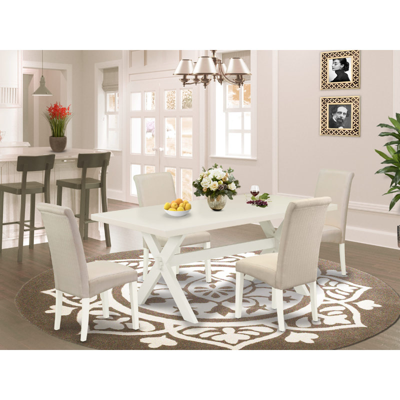 L'ensemble de table de cuisine comprend une table de salle à manger rectangulaire avec pieds en X et chaises rembourrées en tissu crème, lin blanc