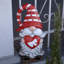 Gnome de jardin en magnésium tenant un cœur avec un nœud et un chapeau rayé rouge "The Valentinos"