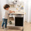 Freniland - Table à outils multifonctionnelle pour enfants avec banc de travail, tableau noir, armoire de rangement, effets sonores et pieds réglables Schima