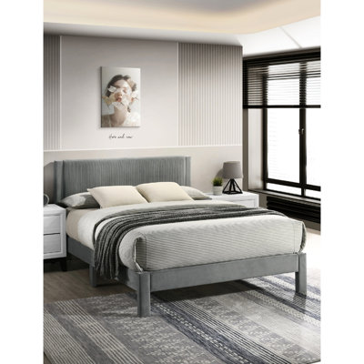 Grand lit plateforme gris contemporain avec tête de lit tapissier nervurée et structure à profil bas pour une chambre à coucher avec texture et ambiance