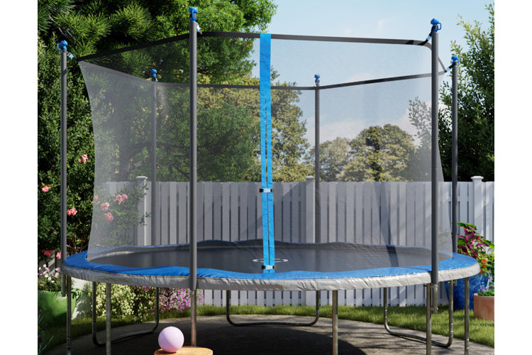 Large round above-ground trampoline with a safety net set up on a patio beside a fence.