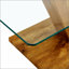 Une table basse de style minimaliste moderne. Plateau de table en verre trempé transparent avec colonnes en bois aggloméré
