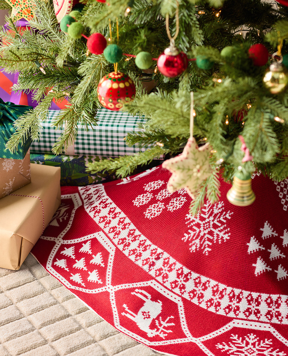 Christmas tree with gifts and a red and white tree skirt.