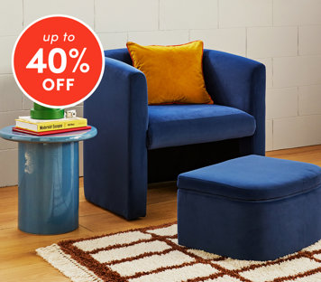 Chairs up to 40% off featuring blue velvet armchair with orange pillow and matching ottoman