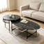 Ensemble de tables basses gigognes noires, modernes et minimalistes, avec plateaux ronds et ovales