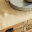 Banc de rangement en bois brun à motif floral avec plateau en toile de jute crème